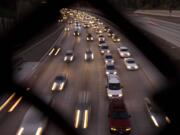 FILE - In this Nov. 22, 2011 file photo, cars travel on a freeway in San Diego. During the long 2014 holiday weekend, 46.3 million Americans are expected to go 50 miles or more from home, the highest number since 2007, according to travel agency and car lobbying group AAA. That would be a 4.2 percent increase over last year.