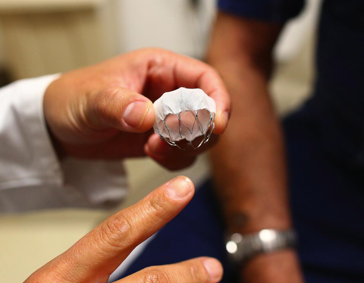 Liz Perpetua holds the new Watchman device at the University of Washington Medical Center on Aug.