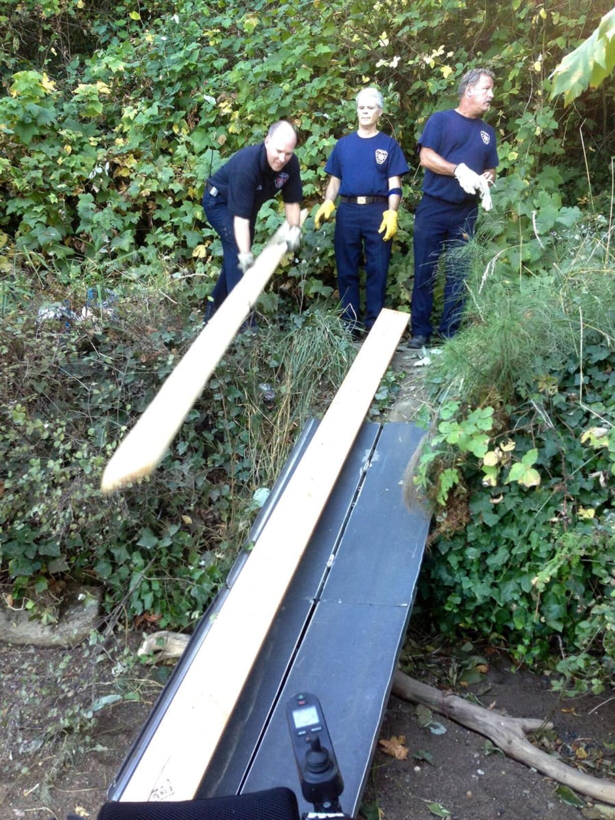 To get the woman's 350-pound wheelchair back on the trail at Lacamas Lake, firefighters made a wooden ramp.