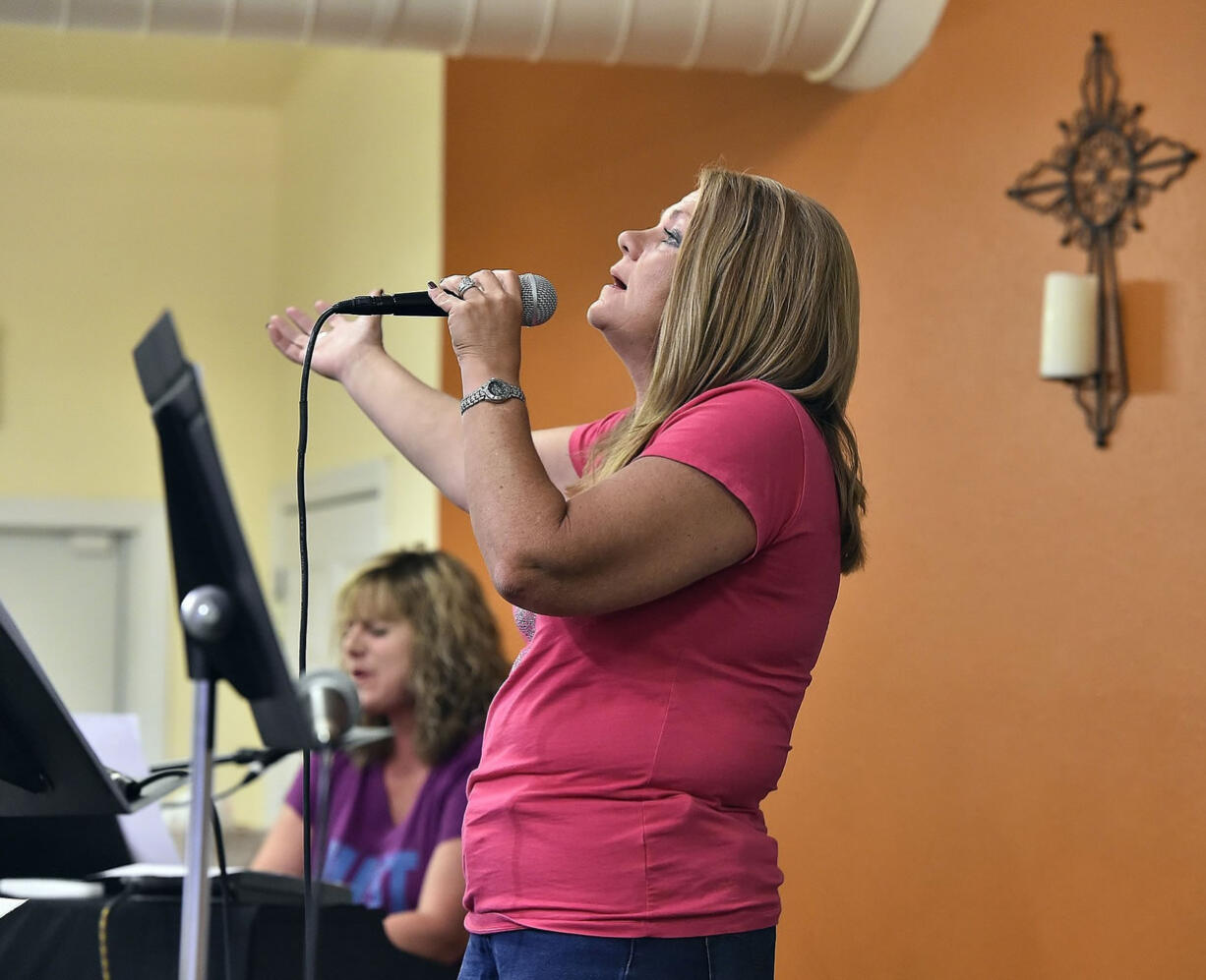 Shawna Coffman rehearses before the start of a church service Aug. 15, 2014 in Raymore, Mo. Shawna and Kevin Coffman's Saved by Grace Fellowship in Raymore, Mo., has become a haven for people fighting severe addiction. Every Friday, people come to their small, rural Cass County church for the Celebrate Recovery service.