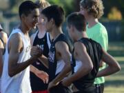 Camas runner Said Guermali, left, greets members of the Union cross country team before a race Tuesday at Pacific Park.