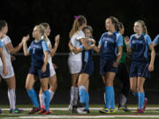 Ridgefield's Taryn Ries (center, in white) gives a post-game hug to Hockinson's Rylee Seekins after the Spudders' overtime win against the Hawks last week.