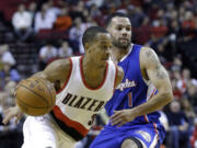 Portland Trail Blazers guard CJ McCollum, left, drives past Los Angeles Clippers guard J.J. Redick during the second half of an NBA pre-season basketball game in Portland, Ore., Sunday, Oct. 12, 2014.