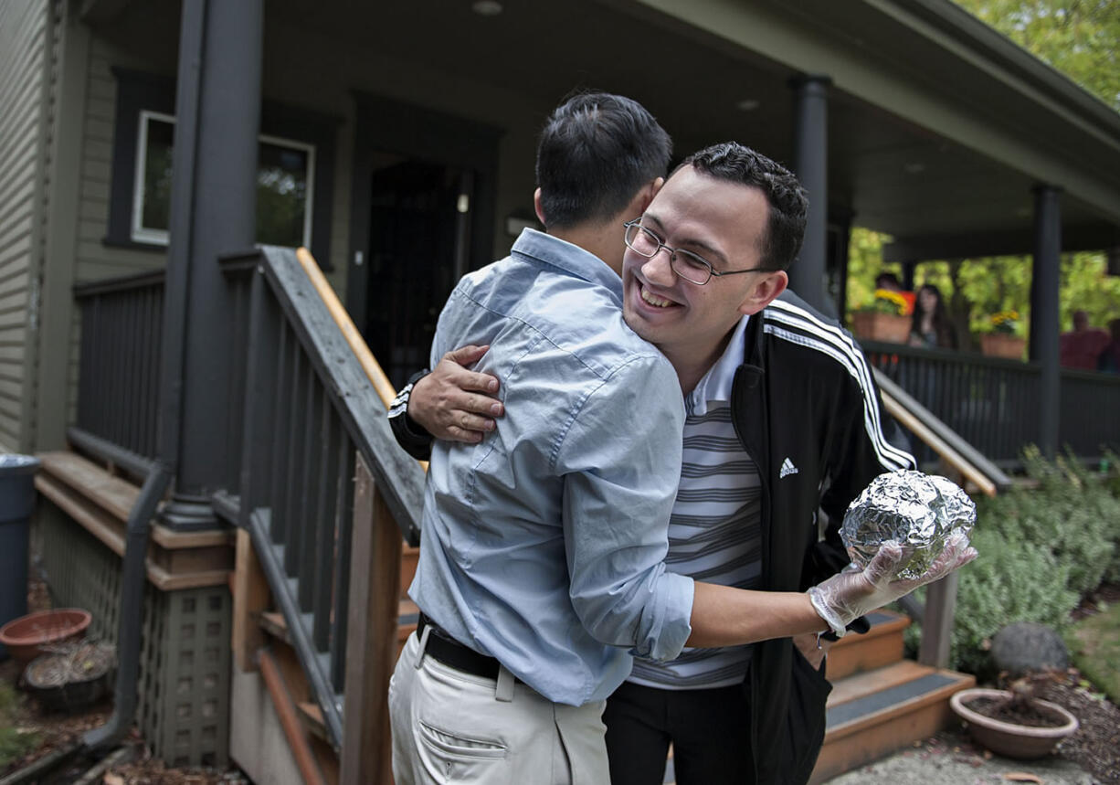 Joseph Matter, Clark County Youth Commission alumnus, facing, embraces fellow alumnus Max Hsiao as they gather for a barbecue at the Clark County Youth House on Monday afternoon, August 31, 2015.