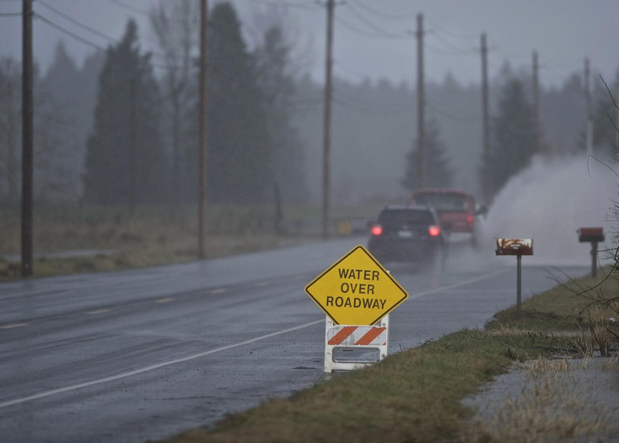 A vehicle drives through high water in Battle Ground last winter.