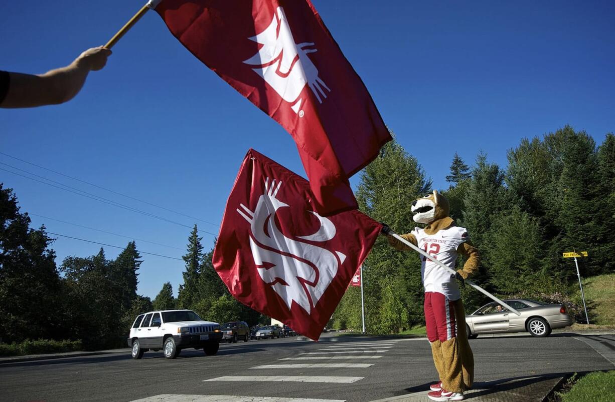 Washington State University Vancouver students are welcomed on the first day of classes by school mascot Butch T. Cougar and others waving WSU flags on Aug. 25.