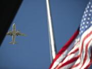 A plane passes overhead as the American flag is raised Sept.