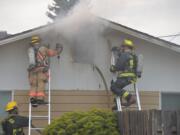 Firefighters battle an attic fire in a home at 307 S.E. 105th Ave.