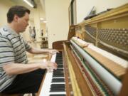 Piano tuner Sam Stahl tests a Kawai piano that was donated to the new Hough Early Learning Center. The School of Piano Technology for the Blind has launched a program connecting used-piano donors with appropriate placements.