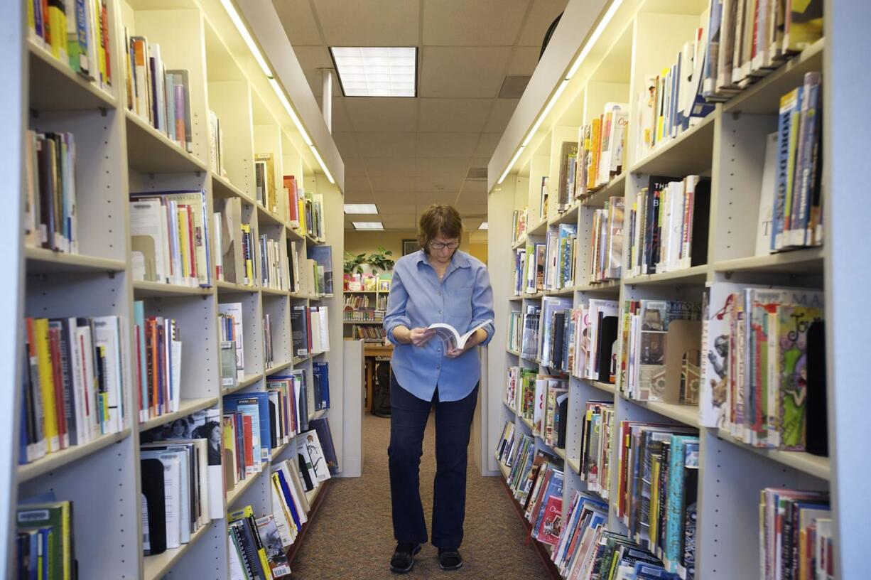 Library assistant Caroline Ketman restocks shelves at the Ridgefield Community Library on March 14.