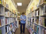 Library assistant Caroline Ketman restocks shelves at the Ridgefield Community Library on March 14.