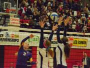 Columbia River's Andrea Demlow (3) hits the ball over Auburn Riverside's blockers during the first set of a Class 3A state semifinal match Saturday in Lacey.