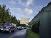 A man panhandles along a highway offramp in Vancouver.