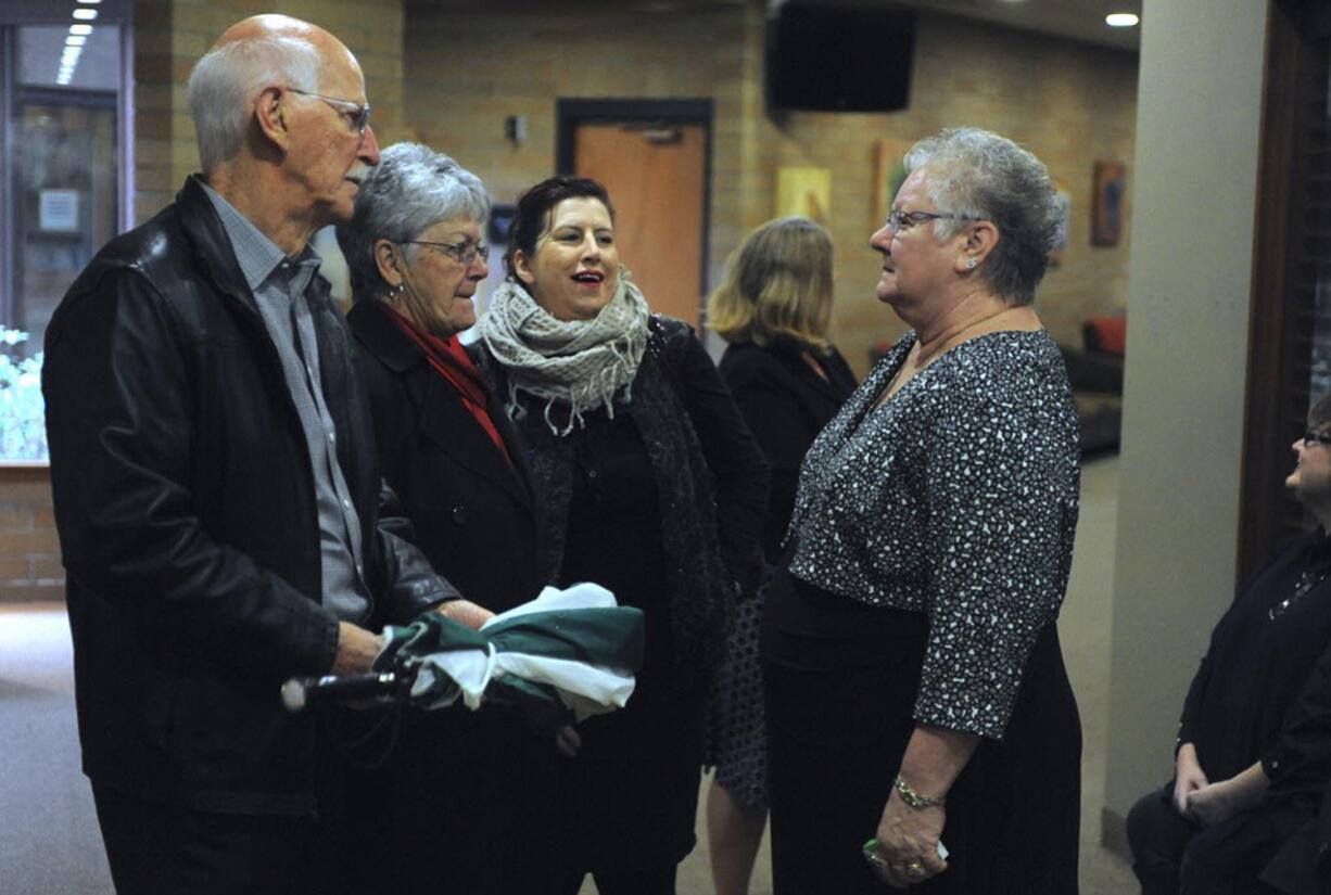 Friends and family gather around Sherry Van Cleve, right, at a memorial service for her husband, Bud Van Cleve, at the Vancouver First Church of God.