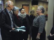 Friends and family gather around Sherry Van Cleve, right, at a memorial service for her husband, Bud Van Cleve, at the Vancouver First Church of God.