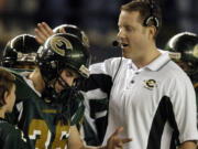 Evergreen High School football coach Cale Piland congratulates Kane Rable during introductions before the start of the 4A state football championship game in 2004.