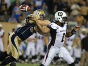 Winnipeg defensive end Greg Peach, left, forces a fumble in a Canadian Football League game against the Ottawa Redblacks.