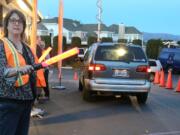 Amy Wilhelm directs traffic at the start of the drive-thru prayer service earlier this month at Holy Spirit Church in Fremont, Calif. The service is offered from 5 to 7 p.m.