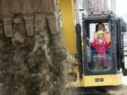 Lillian Vallandingham, 7, a first-grader at Sifton Elementary, runs an excavator with help from Jeff Bullinger from Nutter Corporation.