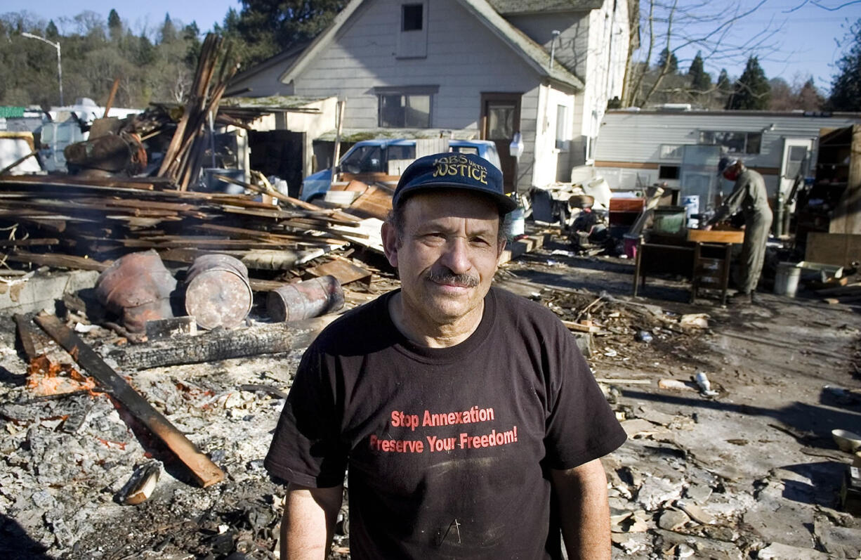 Ted Pyle in 2006, standing beside the remains of a structure on his property that he tore down and torched.