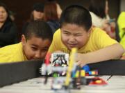 Banana Bot teammates Mohammed Alamin, left, and Dao Zhu compete in a robotics tournament Sunday at Salmon Creek Elementary School.