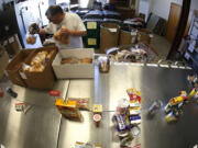 Volunteer Martin Shellabarger sorts donated food items at Families Forward'S warehouse-sized pantry in Irvine, Calif.