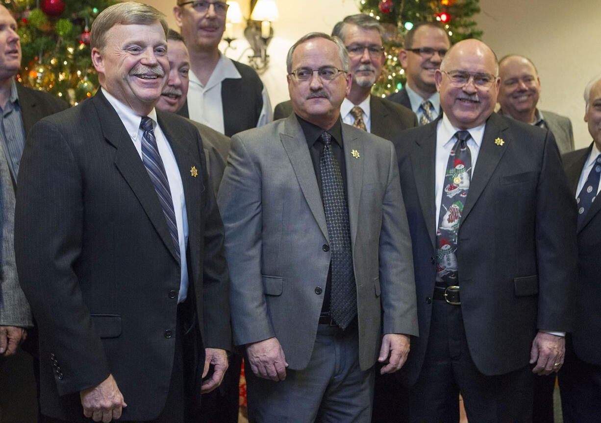 From left, Chief Criminal Deputy Mike Evans, Undersheriff Joe Dunegan and Sheriff Garry Lucas take photos with speakers at their retirement party at the Heathman Lodge Tuesday evening.