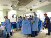 Dr. Scott Rushing, center, prepares a 51-year-old patient for a single-site hysterectomy Wednesday in an operating room at PeaceHealth Southwest Medical Center. The single-site surgery uses only one incision -- a 2-centimeter incision in the belly button -- and leaves no visible scar.