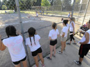 The Ballics watch from their dugout as a teammate kicks the ball at David Douglas Park on a Thursday in late June.