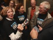 Steve Dipaola/For The Columbian
Charter supporters, from left, Betty Sue Morris, Patty Reyes and Joe Toscano check early election results Tuesday at a rally in The Grant House. Organizers of the effort said they were confident the 9,000-vote lead is insurmountable.