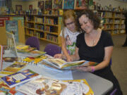 Erin Kutchera and her mom, Nancy, look through one of hundreds of books that were purchased for Hathaway Elementary School's library with donations made in the name of late third-grade teacher Susan Champion.