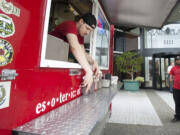 Daniel Honeycutt arranges condiments at the Esoteric BBQ food cart in Vancouver on Tuesday.