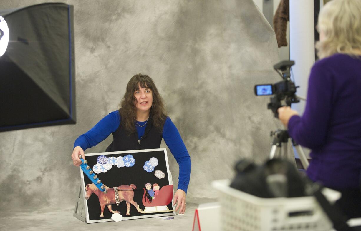 Michele Taylor jingles bells to help young viewers know what she's talking and singing about as Beth Townsend records the December story-telling session for the Fort Vancouver Regional Library's Early Learning website.