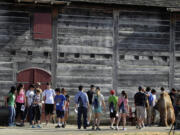 High school students gather at the stockade wall at Fort Vancouver National Historic Site for a selfie scavenger hunt to kick off the Discover Washington: Youth Heritage Project at the fort on Wednesday.