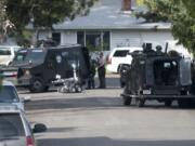 A SWAT team surrounds a home in the Lincoln neighborhood in Vancouver on Friday.