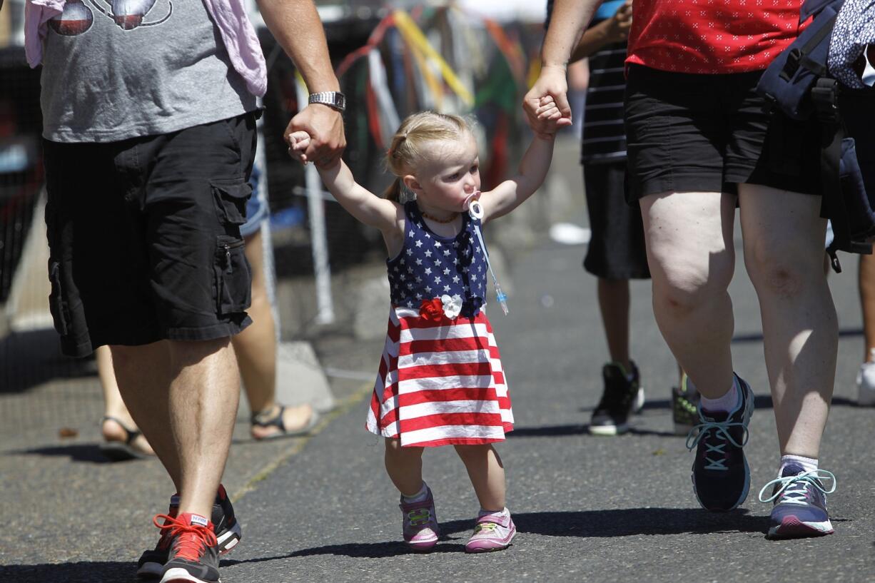 Annalee Symons, 2, from Boise, Idaho, arrives with her parents Logan and Jenni Symons at Independence Day at Fort Vancouver.