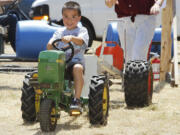 Collin Tobias, 4, of Bremerton rides a toy tractor Sunday at the Rural Heritage Fair, which took place at the Iron Ranch southeast of Ridgefield.