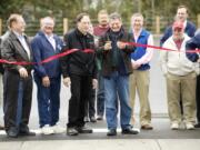 Ridgefield Mayor Ron Onslow cuts a ribbon Thursday during a dedication event for a new park-and-ride lot east of Interstate 5 at the Ridgefield Junction.