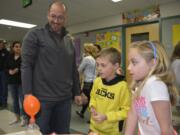 Washougal: John McCormick, left, with his children, Connor and Gabby McCormick, watch a balloon expand from a chemical reaction during Cape Horn-Skye Elementary School's Family Science Night.