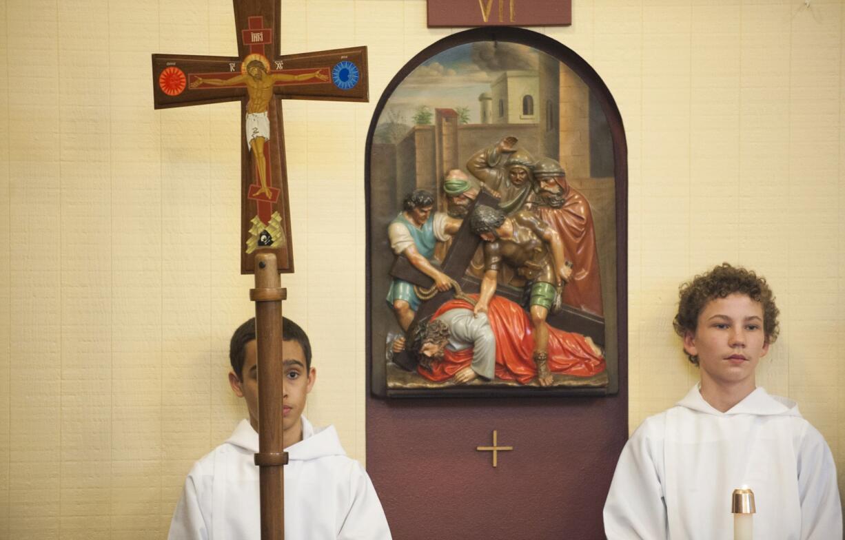 Philip Kuhle, left, and Sam Niehaus, seventh-graders at Our Lady of Lourdes Catholic School in Vancouver, take part in the walking of the Stations of the Cross on Friday, reciting and singing in both English and Spanish.