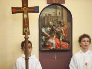 Philip Kuhle, left, and Sam Niehaus, seventh-graders at Our Lady of Lourdes Catholic School in Vancouver, take part in the walking of the Stations of the Cross on Friday, reciting and singing in both English and Spanish.