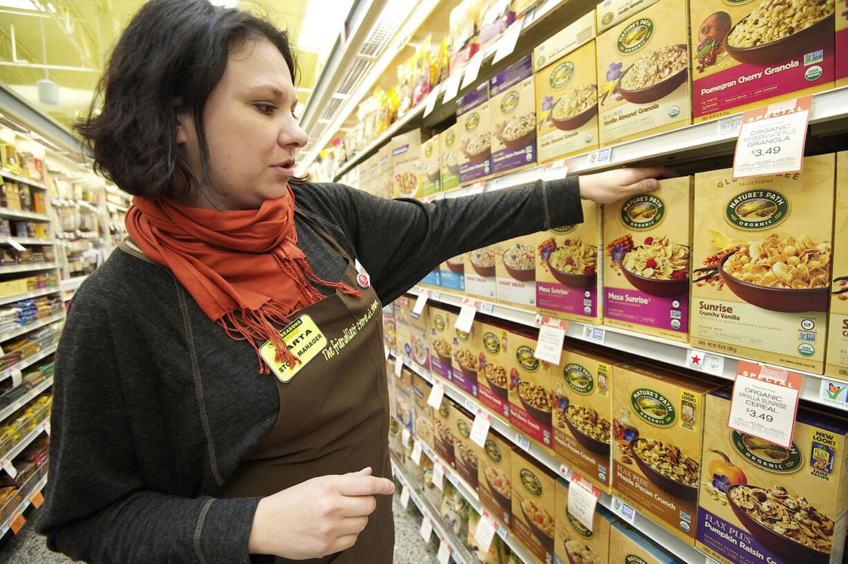 New Seasons store manager Marta Majewska faces a cereal aisle shelf containing products which have GMO labeling Tuesday October 15, 2013 in Vancouver, Washington. New Seasons has worked with the Non-GMO Project to label all foods on its shelves that do not contain any GMOs.