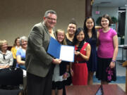 Camas Mayor Scott Higgins, from left, Skylar Becerra, Olivia Love, Holly Ta, Emma Nellor and Sarah Wells-Moran hold Camas' proclamation for International Day of the Girl.