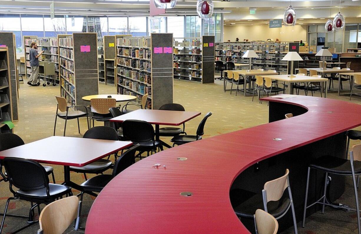 Ryan Ellis, Cascade Park Community Library supervisor, helps stock the shelves in the new facility shortly before it opened in December 2009.