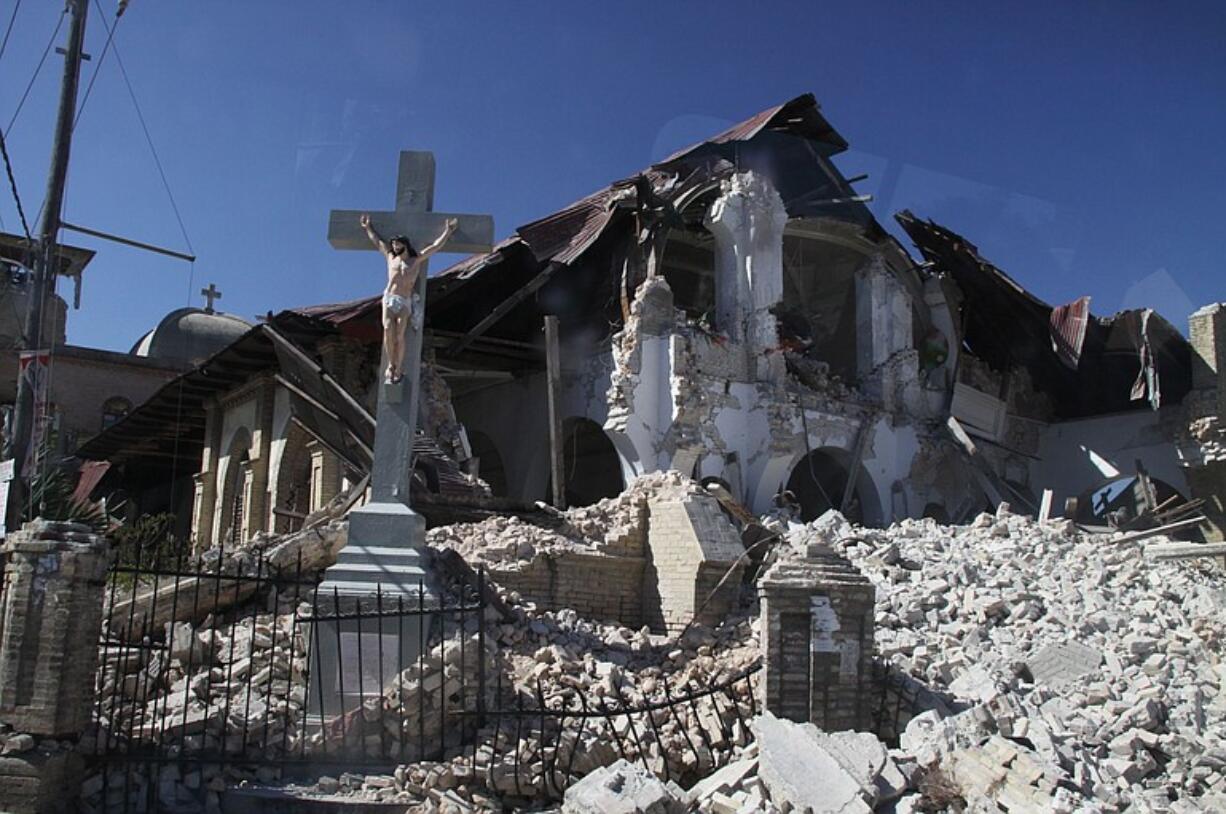 A crucifix remains standing in front of the ruins of Sacred Heart Catholic Church in Port-au-Prince.