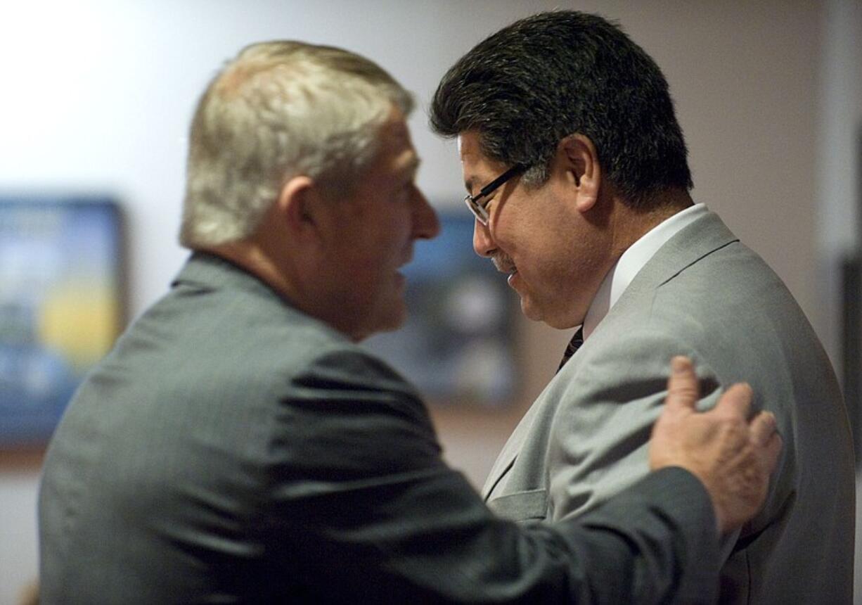 Vancouver City Councilman Larry Smith, left, encourages Police Chief Cliff Cook on Monday before Cook delivered his department's annual performance report.