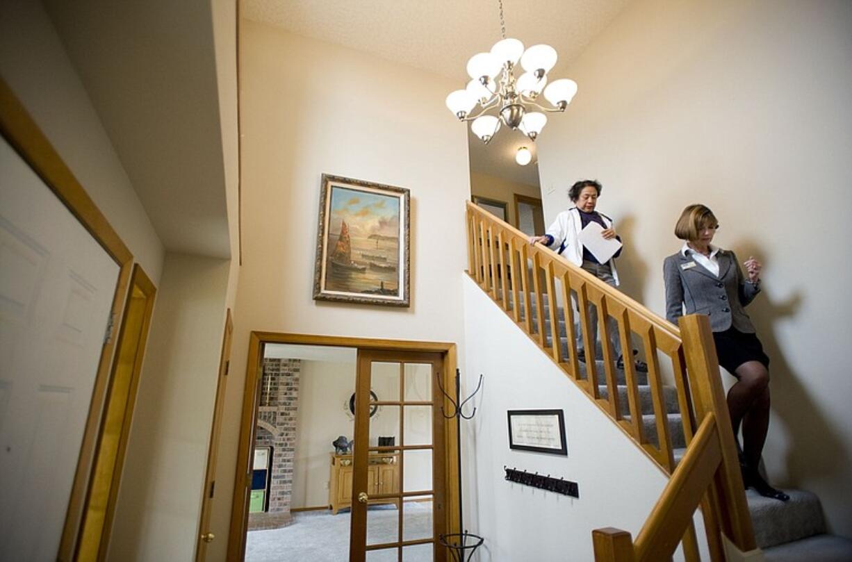 Real estate agent Carolyn Crawford, right, shows a house to Cora Grimm during an open house April 10 in east Vancouver.