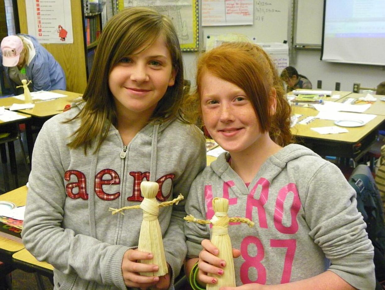 Sifton: Christina Vorobets, left, and Maddison Strode hold the corn husk dolls they made.