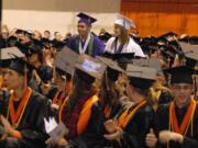 Battle Ground: Anna Downs, in white, and Kevin Stamper, in purple, sit among seniors from Battle Ground High School at the school's graduation ceremony June 18.