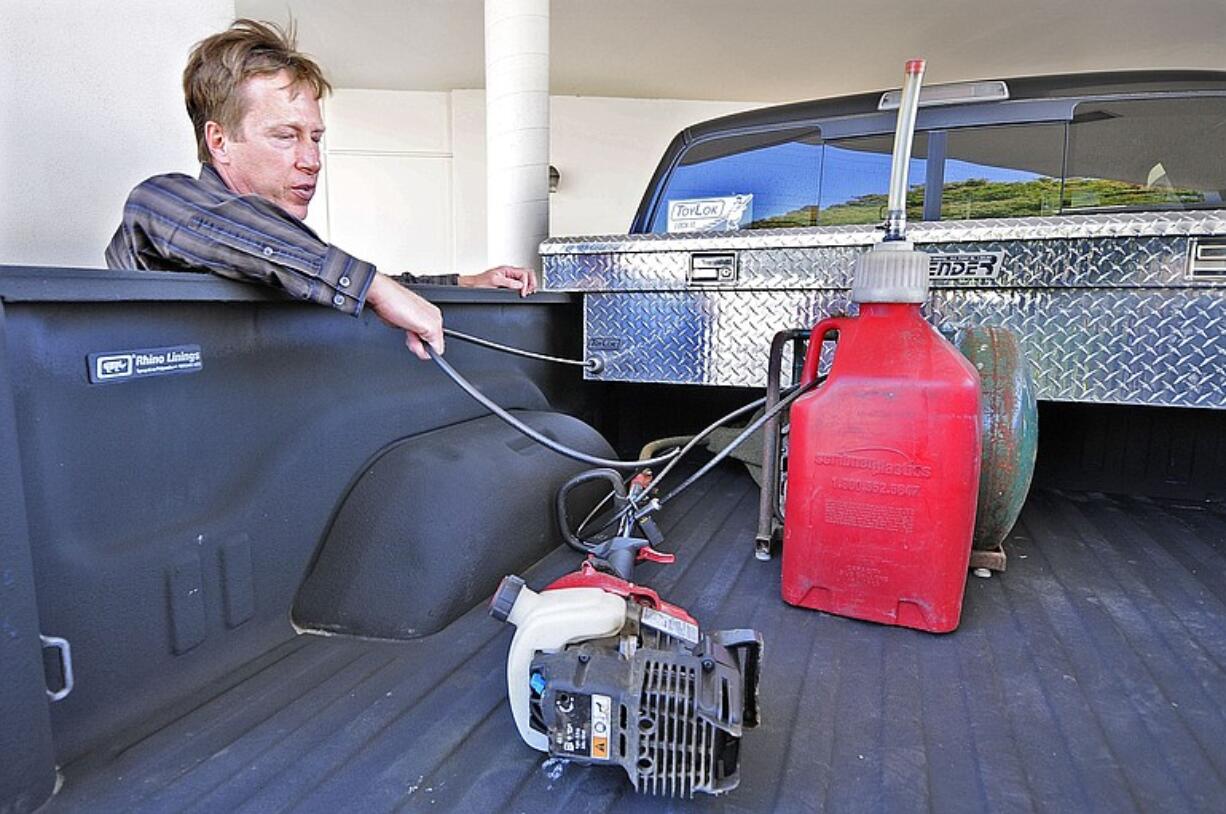 Dale Tollefson demonstrates how his invention, the ToyLok, works to lock up a weed-wacker, gas can and air compressor in the back of his truck.